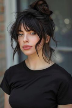 Woman with dark hair in a bun wearing a black t-shirt and looking directly at the camera. Wispy Grunge Bangs, Thick Wavy Hair With Curtain Bangs, Wavy Ponytail With Bangs, Thick Hair Styles Women, Wavy Hair Bangs Hairstyles, Medium Length Goth Hairstyles, Long Wavy Bangs, Bangs For Long Wavy Hair, Wavy Fringe Hairstyles