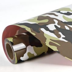 a roll of camouflage wrapping paper on top of a white table with a red tape