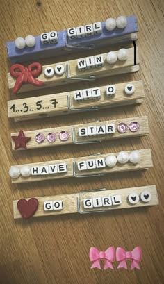 three wooden pegs with words and bows on them, each spelling out the word