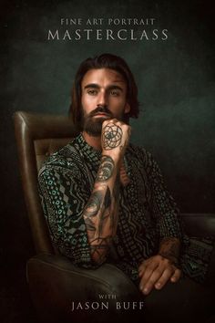 a man sitting in a chair with his hand on his chin and tattoos on his arm