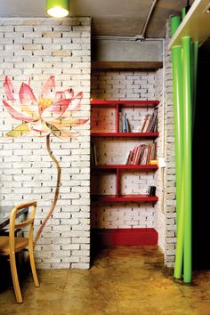 a room with bookshelves and a flower painted on the wall