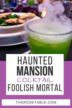 a green drink with steam coming out of it and the words, haunted mansion cocktail