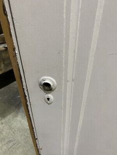 an open door with a white handle and knobs on the outside side of it