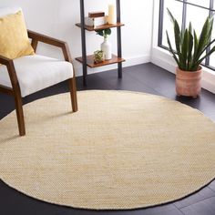 a living room area with a chair, table and potted plant on the floor