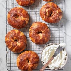 six bagels on a cooling rack with whipped cream