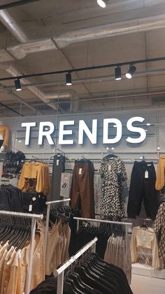 a clothing store display with clothes on racks and the words trend's above it