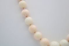 This is an incredible necklace made of Angel skin coral shell. Mostly white in color with some minor coral/pinkish tones. The beads are graduated with the center being the largest at approx 12 mm (see photo). Condition; Good vintage condition, no chips or visible damage. Clasp has a heavy patina due to age. Size; The largest bead is about 12mm, the next size down is about 10mm and the length of the necklace is approximately 22 inches long. Hallmarks; Clasp is sterling silver (tested) but there i Elegant Coral Beaded Necklaces With Large Beads, Elegant Coral Necklaces With Large Beads, Beaded Necklace White, Angel Skin, Coral Beads Necklace, Necklace White, Coral Beads, Pearl Shell, Sunset Beach