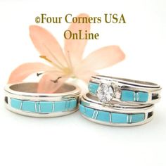 two wedding rings with turquoise and white stones on each one, sitting next to a flower