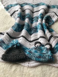 two crocheted afghans laying next to each other on top of a white blanket