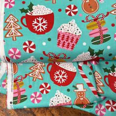 a close up of a cloth with christmas decorations on it and candy canes in the background