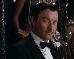 a man in a tuxedo looks at the camera