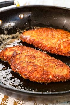 two fried fish fillets in a frying pan