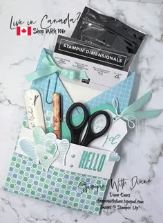 scissors and other items in a box on a marble counter top with canadian stamping