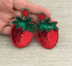 "Strawberry Earring * 1 pair * Size: approx. 2.5\" x 1.75\" * Push Back * Seed Beads, Sequin" Trendy Red Festive Jewelry, Trendy Red Jewelry For Festive Occasions, Handmade Red Earrings For Holiday, Handmade Red Earrings For The Holiday, Green Earrings For Valentine's Day Party, Handmade Red Holiday Earrings, Handmade Red Beaded Earrings For Holiday, Holiday Red Beaded Earrings, Holiday Red Handmade Beaded Earrings