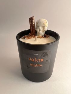 an ice cream dessert in a black cup with a skeleton on it's head