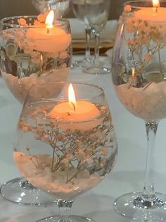 candles are lit in glass vases on a table