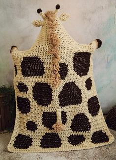 a crocheted giraffe pillow sitting on top of a table