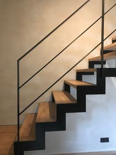 a set of stairs with wooden treads in an empty room