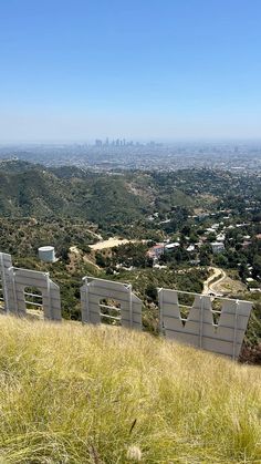 the hollywood sign on top of a hill with cityscape in the back ground