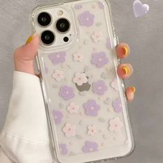 a woman holding an iphone case with flowers on it