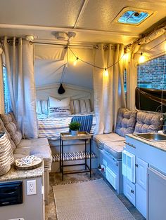 the interior of a camper is decorated with blue and white decor, including curtains