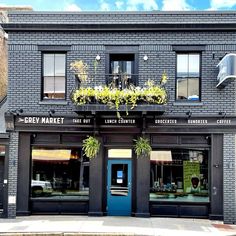 the front of a building with plants growing out of it's windows and doors