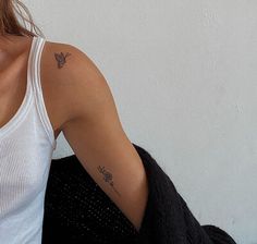 a woman with a butterfly tattoo on her left arm and right arm behind her back