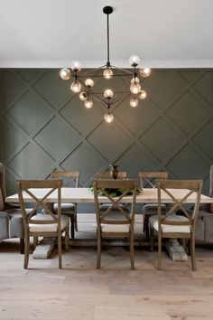 a dining room table with six chairs and a chandelier hanging from the ceiling