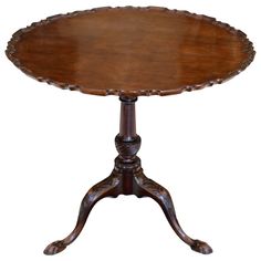 an old fashioned wooden table with ornate carvings on the legs and top, sitting against a white background