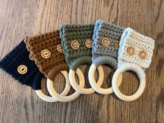 four crocheted rings are sitting next to each other on a wooden surface,