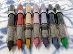 several different colored pens lined up on a table