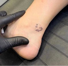 a person with a tattoo on their foot and gloved hand next to the foot