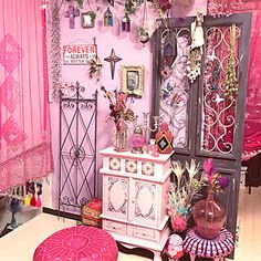 a room filled with lots of pink furniture and decor on top of wooden flooring