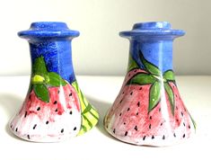 two ceramic vases with painted designs on them