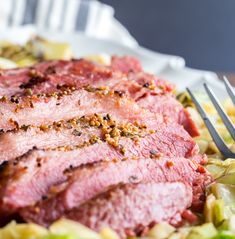 a close up of a plate of food with meat and vegetables next to a fork