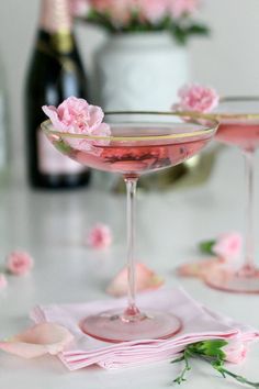 two glasses filled with pink liquid on top of a table