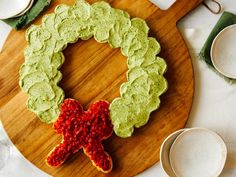 a wooden platter topped with green and red cookies