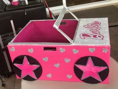 a pink box with silver stars and hearts on the side, sitting on a table