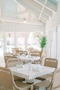 a dining room with white tables and chairs