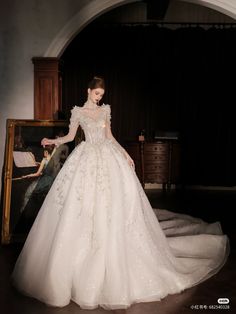 a woman in a white wedding dress standing next to a piano