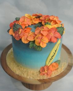 there is a blue cake with orange flowers on it