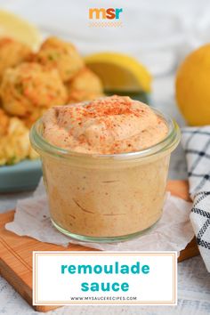 a small glass jar filled with homemade sauce next to lemons and other food items