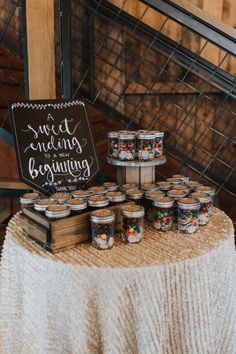 a table topped with jars filled with food next to a sign that says sweet wedding brunch