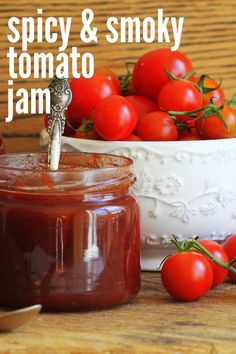 a jar of tomato jam next to a bowl of cherry tomatoes with the words spicy & smoky tomato jam