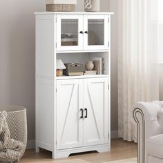 a white cabinet with glass doors in a living room