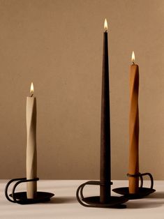 three candles sitting on top of each other with one candle in the middle and another burning