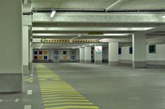 an empty parking garage with yellow and white lines on the floor in front of it