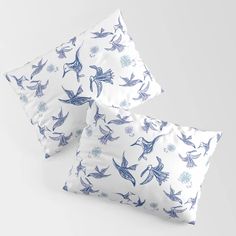 three pillows with blue birds on them, one is white and the other is blue