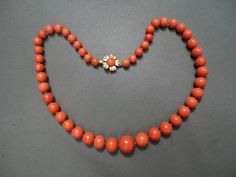 This is such a wonderful coral Mediterranean necklace. Beautiful shade of rich tomato red color with a nice flower clasp. Marked 14 KT on the tongue piece. Center bead is just over 12 mm which is exactly 1/2 inches. Tappers down to 7 mm. Total weight is 43.2 grams. I like the flower clasp -- so pretty. Hard to find large beads. Natural growth lines visible as shown in pictures. Good condition to the beads, very minimum blemishes. Necklace is 17 inches long. Impossible to find beads of this size. A treasure to own and a heirloom piece to pass down. Luxury Polished Red Coral Beads, Formal Single Strand Red Coral Jewelry, Classic Red Coral Formal Jewelry, Vintage Mediterranean, Nice Flower, Large Bead Necklace, Red Coral Necklace, Coral Beads Necklace, Graduation Necklace