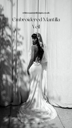 a woman in a wedding dress standing next to a wall with the shadow of a tree on it